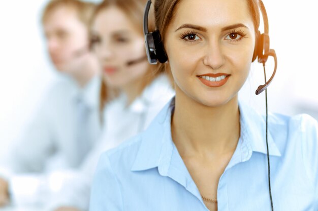 Operadores de centros de llamadas. Concéntrese en una hermosa mujer de negocios con auriculares.