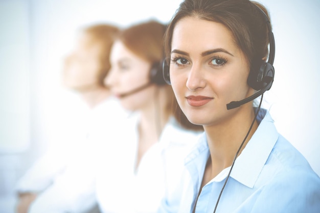 Operadores de centros de llamadas. Concéntrese en una hermosa mujer de negocios con auriculares.