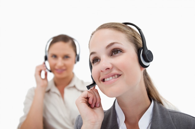 Operadores sonrientes que usan auriculares