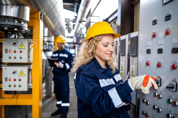 Operária feminina operando usina em refinaria de petróleo e gás