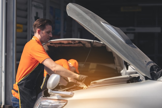 Operário de reparos polindo carroceria de automóvel na garagem