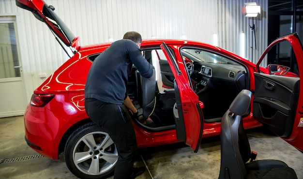 Operário de serviço automotivo desmonta o interior do carro