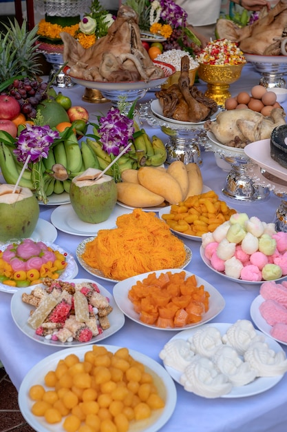 Opfergabe von Speisen zum Beten zu Gott und zum Denkmal für den Vorfahren, Bangkok, Thailand. Nahaufnahme. Traditionelle Opfergaben an Götter mit Essen, Gemüse und Obst für die Götter der thailändischen Kultur