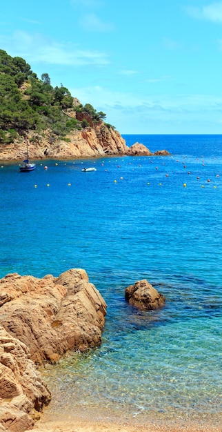 Opinião da costa do verão da baía de Tamariu com barcos, Costa Brava, na Catalunha, Espanha. Dois tiros costuram a imagem.