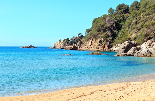 Opinião do verão da costa rochosa do mar Mediterrâneo com praia de areia (Costa Brava, Catalunha, Espanha.
