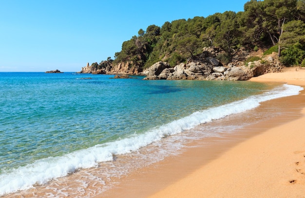 Opinião do verão da costa rochosa do mar Mediterrâneo com praia de areia (Costa Brava, Catalunha, Espanha).