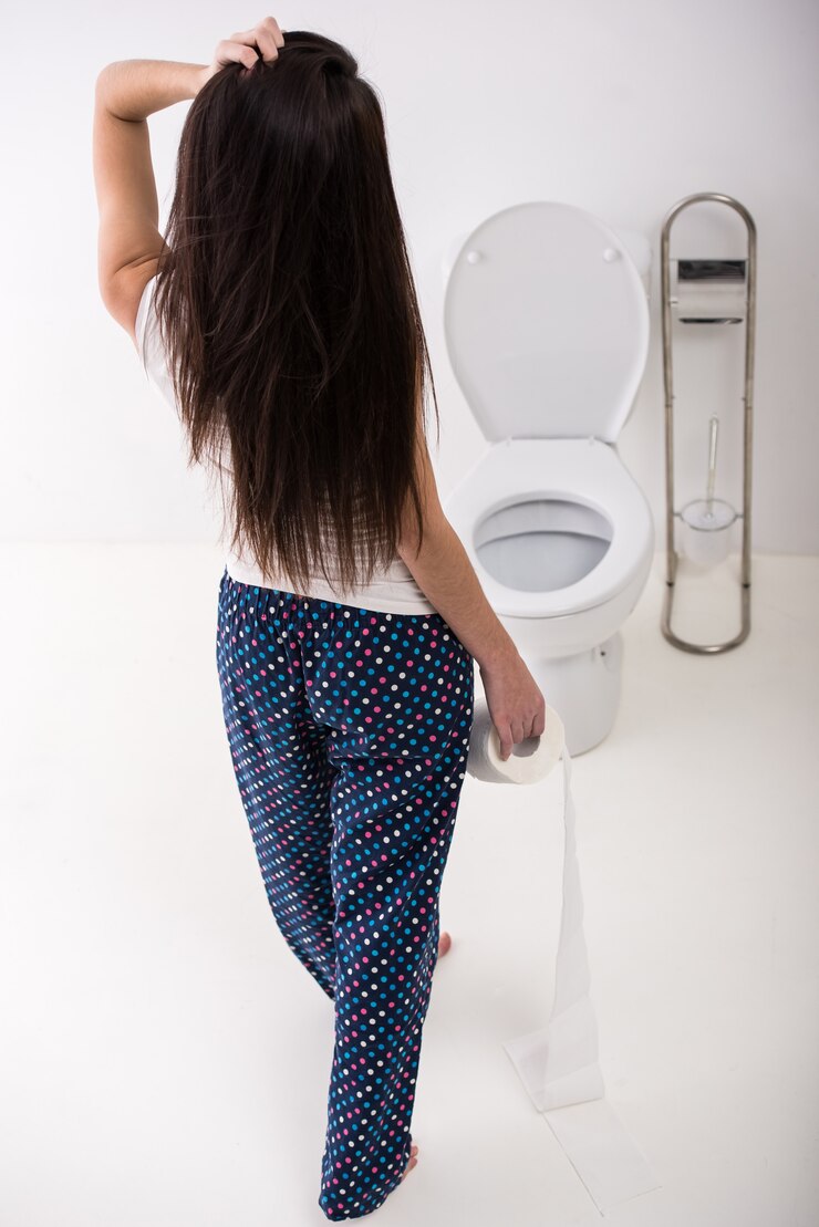 Foto opinião traseira a mulher com papel no toalete na manhã.
