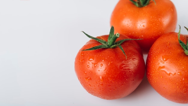 Opinión de alto ángulo de tomates rojos frescos en el fondo blanco