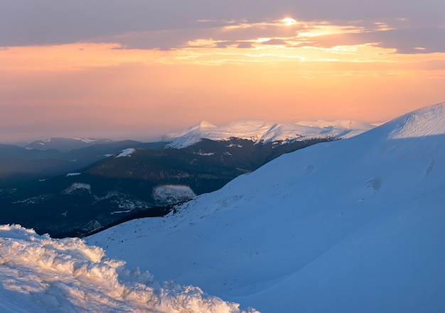 Opinión del crepúsculo de la cresta de la montaña del invierno en los últimos rayos de sol de la tarde (Ucrania, Cárpatos).