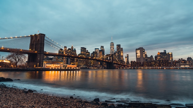 Opinión de la noche del paisaje urbano del puente y de los edificios de Brooklyn en Manhattan New York City, Estados Unidos.