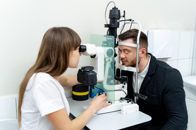 Foto Óptico especialista en pruebas de la vista joven optometrista examinando los ojos de los pacientes