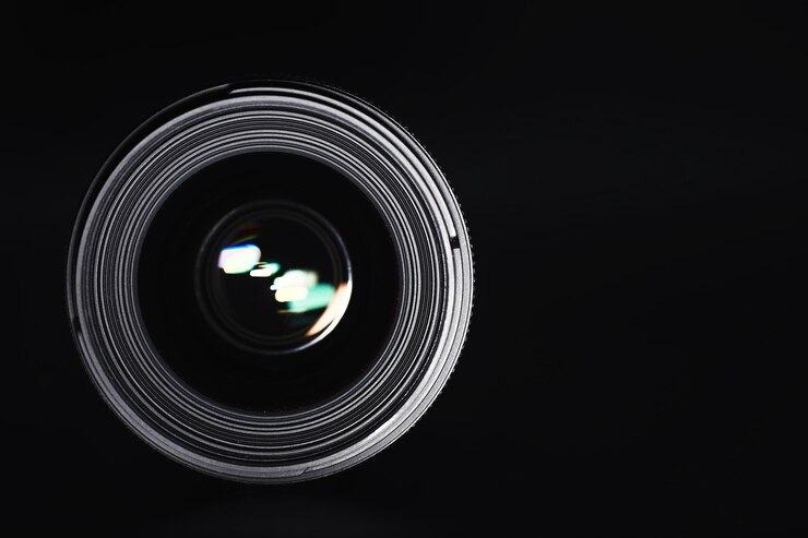 Foto optik zur kamera am bedienpult. flare im glas eines fotoobjektivs. schwarzer hintergrund mit der technik des fotografen.
