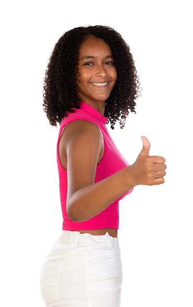 Optimistische junge schöne Afroamerikanerin mit rosafarbenem T-Shirt vor weißer Wand, die Daumen nach oben mit positiven Emotionen zeigt