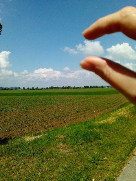 Foto optisches illusionsbild einer hand, die eine wolke über einem hof hält