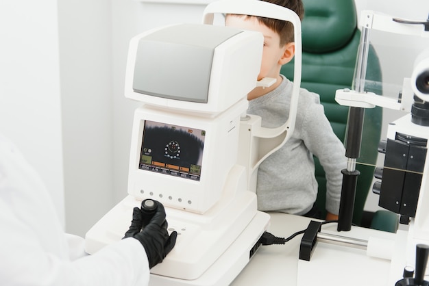 Optometrie-Konzept. Optikerin Optikerin untersucht das Sehvermögen eines Jungen in einer Augenklinik