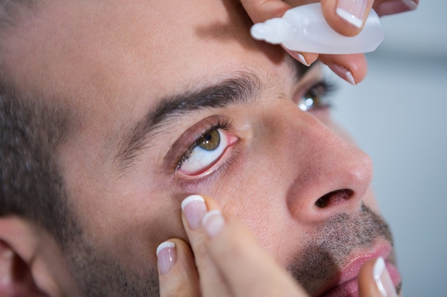 Optometrista colocando gotas nos olhos dos pacientes