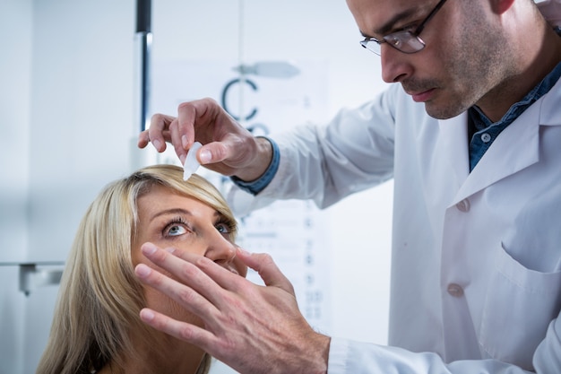 Optometrista colocando gotas nos olhos dos pacientes