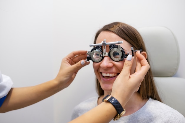 Foto optometrista escolhendo lentes para teste de paciente