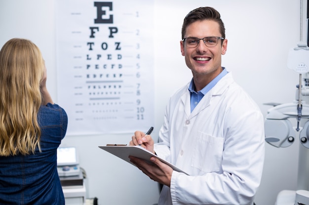 Optometrista escrevendo na área de transferência