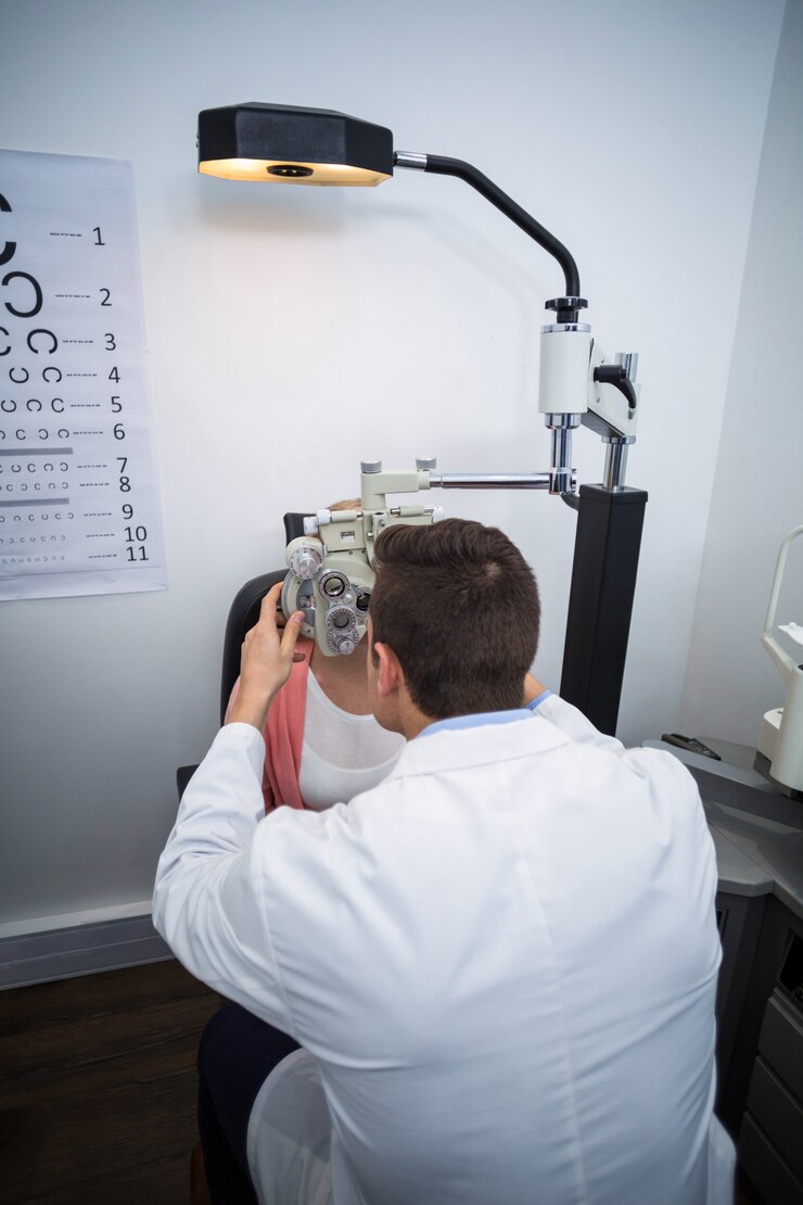 Foto optometrista examinando paciente do sexo feminino no phoropter