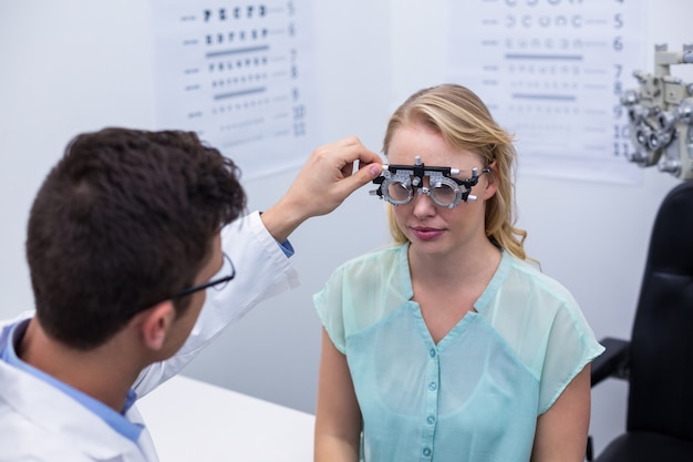 Optometrista examinar paciente do sexo feminino com messbrille