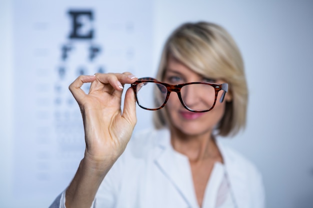 Optometrista feminina segurando óculos