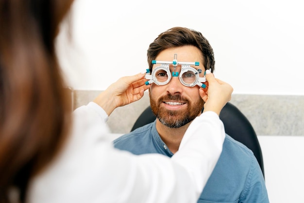 Foto optometrista feminina verificando a visão no olho para o homem em clínica moderna pessoas de medicina de cuidados de saúde