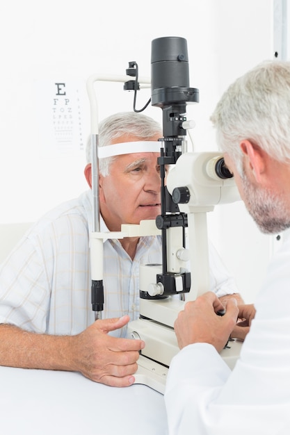 Optometrista haciendo prueba de vista para paciente senior