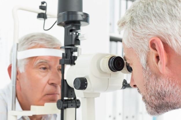 Foto optometrista haciendo prueba de vista para paciente senior