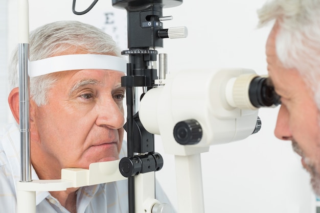 Optometrista haciendo prueba de vista para paciente senior