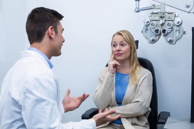 Optometrista interactuando con paciente femenino