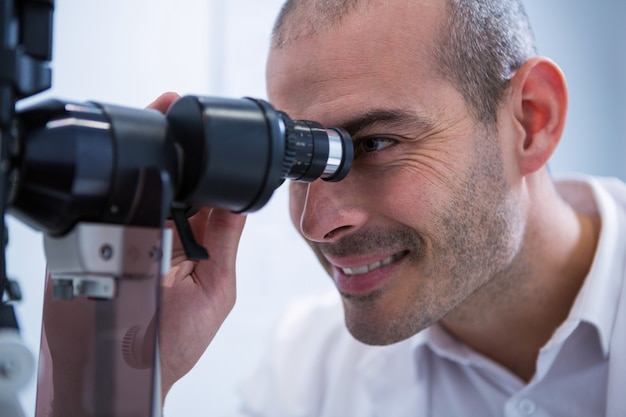 Optometrista mirando a través del biomicroscopio