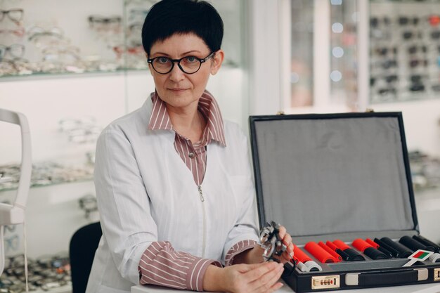 Optometrista mujer óptica con kit de lentes de prueba oftálmica