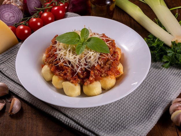 Ñoquis boloñesa con salsa de tomate natural ecológico, sin pesticidas, con queso parmesano rallado y hojas de albahaca