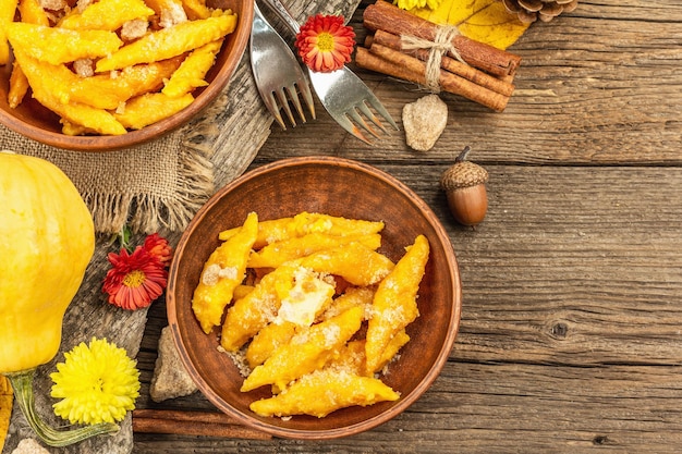 Ñoquis de calabaza o albóndigas italianas. Plato de calabaza vegetariana saludable con requesón. Decoración de otoño con hojas de otoño, conos, calabazas enteras maduras, flores y especias. Fondo de madera vieja, vista superior