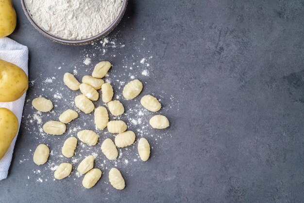 Ñoquis de pasta italiana sin cocer sobre fondo de piedra.