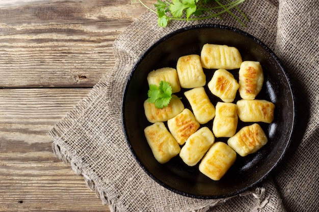 Ñoquis de patata caseros. Endecha plana. Fondo negro.