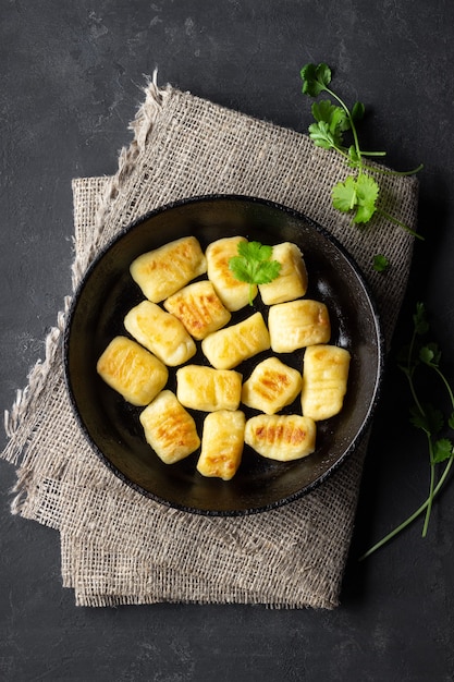 Ñoquis de patata caseros. Endecha plana. Fondo negro.