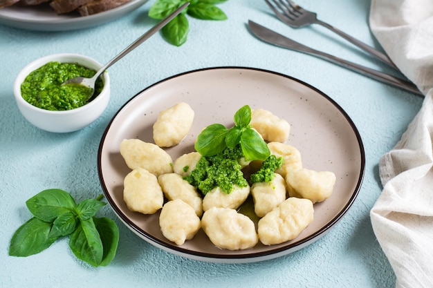 Ñoquis de patata con salsa pesto en un plato sobre la mesa Cocina tradicional italiana Primer plano