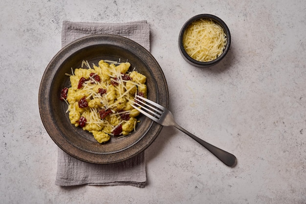 Ñoquis de patata tradicional mediterránea y alpina con parmesano y tomates secos en cerámica