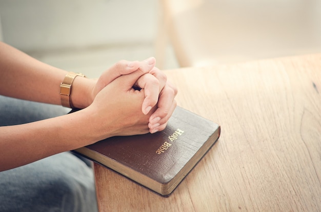 Foto oração bíblica cruze as mãos na bíblia, ore espiritual e religioso comunique-se com deus, amor e perdão.