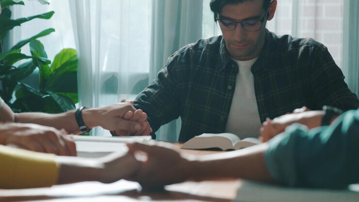 Foto oração cristã segurar um ao outro apoio enquanto ora a deus na mesa simposium