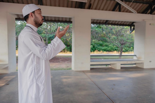 Oração do homem islâmico asiáticoJovem muçulmano orandoConceito do festival do Ramadã