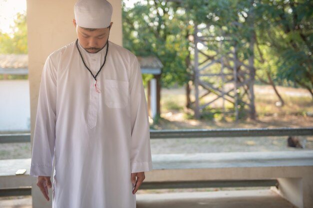 Oração do homem islâmico asiáticoJovem muçulmano rezandoConceito do festival do Ramadã