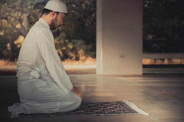 Foto oração do homem islâmico asiáticojovem muçulmano rezandoconceito do festival do ramadã