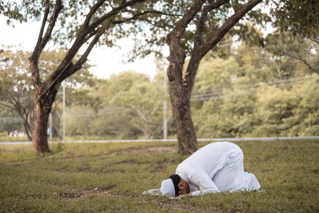 Oração do homem islâmico asiáticoJovem muçulmano rezandoConceito do festival do Ramadã