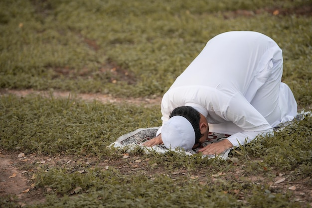 Oração do homem islâmico asiáticoJovem muçulmano rezandoConceito do festival do Ramadã