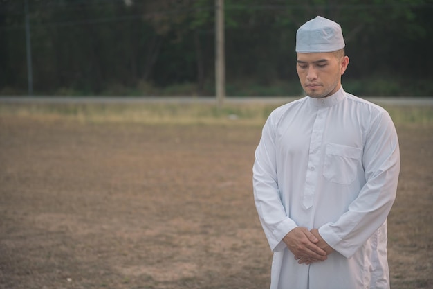 Oração do homem islâmico branco asiáticoJovem muçulmano rezandoConceito do festival do Ramadã