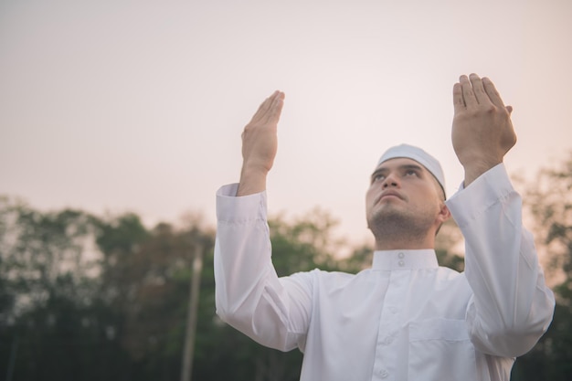Oração do homem islâmico branco asiáticoJovem muçulmano rezandoConceito do festival do Ramadã