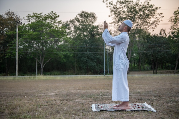 Oração do homem islâmico branco asiáticoJovem muçulmano rezandoConceito do festival do Ramadã